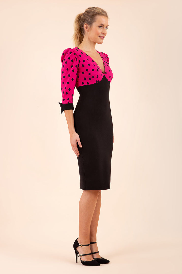 blonde model wearing diva catwalk bristow vintage three quarter sleeve pencil floral dress with low v neckline and puffed shoulders in pink polka dot top and black front