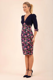 blonde model wearing diva catwalk bristow vintage three quarter sleeve pencil floral dress with low v neckline and puffed shoulders in navy top front