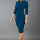 model wearing Diva Catwalk pencil three quarter sleeve dress with a split neckline and pleating across the tummy in autumn teal front