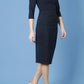 model wearing Diva Catwalk pencil three quarter sleeve dress with a split neckline and pleating across the tummy in midnight blue front