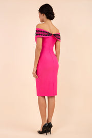 brunette model wearing diva catwalk kurumba pencil dress with bardot off shoulder neckline and lace detail across it in hibiscus pink and black colour back