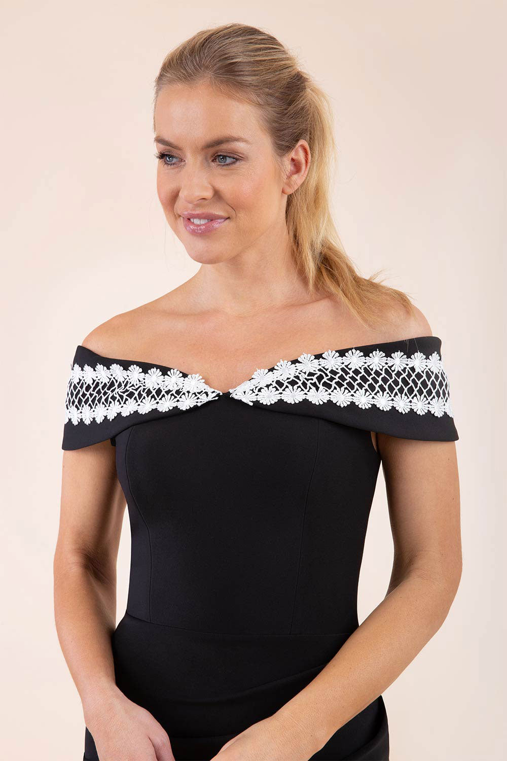 brunette model wearing diva catwalk kurumba pencil dress with bardot off shoulder neckline and lace detail across it in black and white colour front