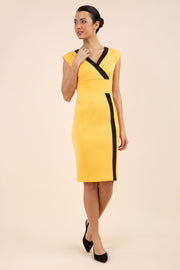 brunette model wearing Diva catwalk Suzy pencil sleeveless dress with v-neckline and wide wasteland in radiant yellow front