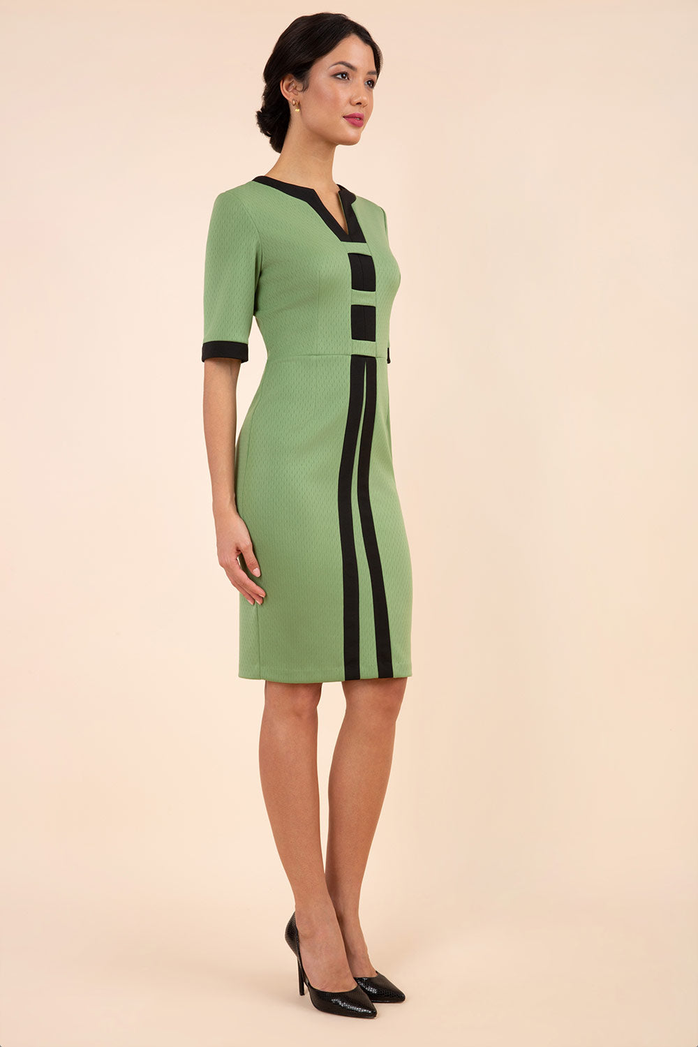 Model wearing the Diva Goggle pencil dress design in green with black, colour block detailing front image