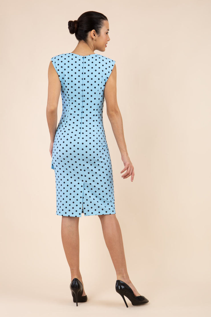 Brunette model wearing Diva Catwalk Perry Polka Dot Pencil Sleeveless Dress with tie detail on a side and rounded neckline in sky blue back