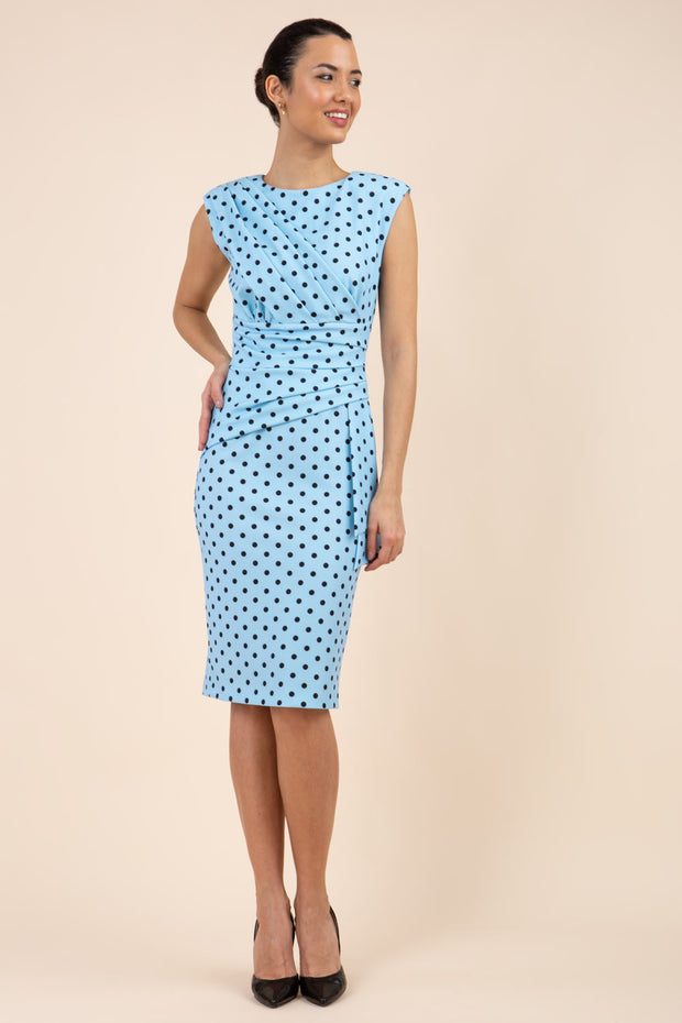 Brunette model wearing Diva Catwalk Perry Polka Dot Pencil Sleeveless Dress with tie detail on a side and rounded neckline in sky blue front