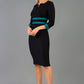 brunette model wearing Diva catwalk Paeonia dress square neckline with a vent in black with Pacific Green and black stripes around the waist and three quarter sleeve with Pacific Green contrast finish front
