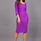 Model wearing Diva catwalk Opulus pencil dress in amethyst purple with three quarter sleeve figure fitted front image