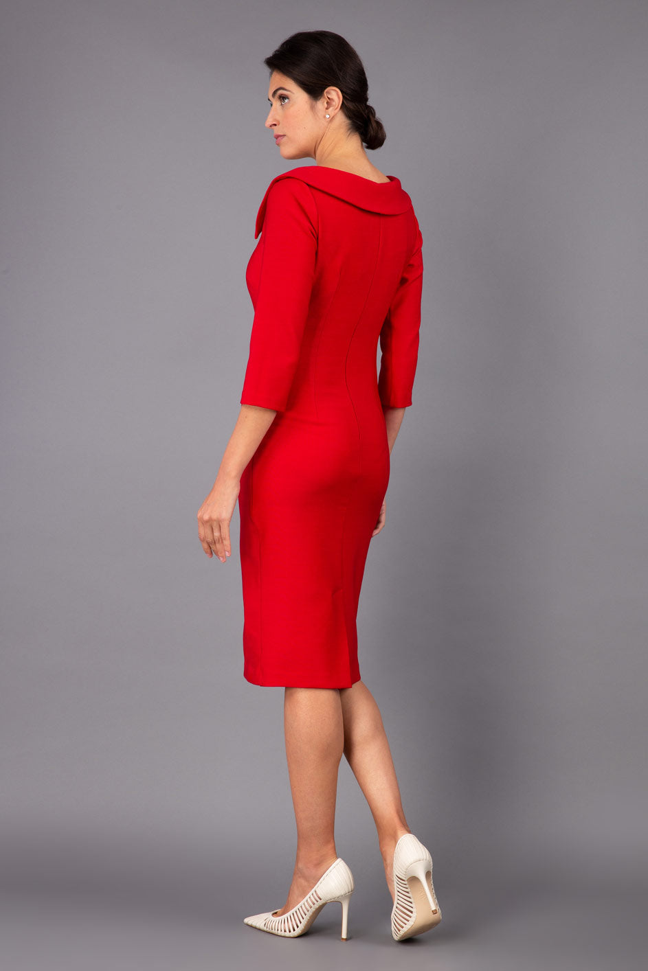 Model wearing Diva catwalk Opulus pencil dress in cardinal red with three quarter sleeve figure fitted back image