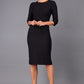 Model wearing Diva catwalk Minette dress in black with three quarter sleeve figure fitted pencil dress front image