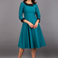 Model wearing Diva catwalk Coralia swing dress in pacific green with three quarter sleeve figure fitted front image