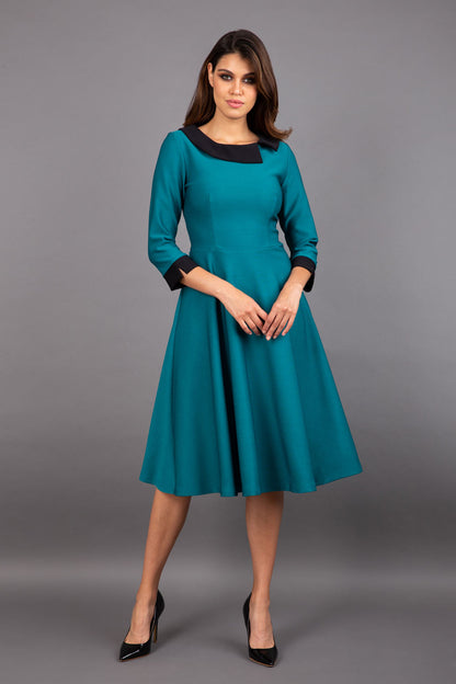 Model wearing Diva catwalk Coralia swing dress in pacific green with three quarter sleeve figure fitted front image