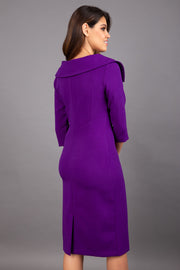 Model wearing Diva catwalk Venetia pencil figure fitted dress in deep purple with three quarter sleeve back