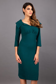Model wearing Diva catwalk Venetia figure fitted pencil dress in forest green with three quarter sleeve front