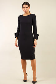 brunette model wearing diva catwalk fitted dress with sleeves called Alma Pencil-skirt dress in colour black with bow detail on sleeves front