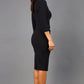 brunette model wearing diva catwalk elodie pencil fitted dress with rounded neckline and button detail and three quarter sleeve with pleating across the body from side triangle detail in black back