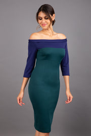 brunette model wearing diva catwalk leon pencil contrast dress with boat off shoulder fold over neckline and three quarter sleeve and empire waistline in forest green and navy blue front