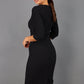 Brunette model wearing Diva Catwalk Lovell Pencil Dress in black  with lowered sweetheart neckline and three quarter sleeve with gathering at the bust back