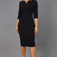 Brunette model wearing Diva Catwalk Lovell Pencil Dress in black  with lowered sweetheart neckline and three quarter sleeve with gathering at the bust front