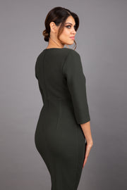 Brunette model wearing Diva Catwalk Lovell Pencil Dress in Obsidian Green with lowered sweetheart neckline and three quarter sleeve with gathering at the bust back