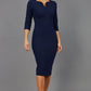 Brunette model wearing Diva Catwalk Lovell Pencil Dress in Navy  with lowered sweetheart neckline and three quarter sleeve with gathering at the bust front