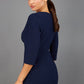 Brunette model wearing Diva Catwalk Lovell Pencil Dress in Navy  with lowered sweetheart neckline and three quarter sleeve with gathering at the bust back