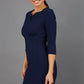 Brunette model wearing Diva Catwalk Lovell Pencil Dress in Navy  with lowered sweetheart neckline and three quarter sleeve with gathering at the bust front