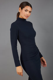 brunette model wearing diva catwalk sasha pencil-skirt dress with long sleeves and high neck in colour dark blue front