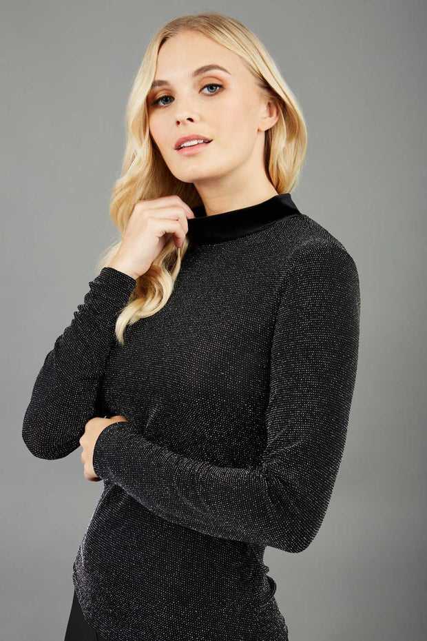 Blonde hair model is wearing a jersey sparkle velvet turtleneck blouse top  front image