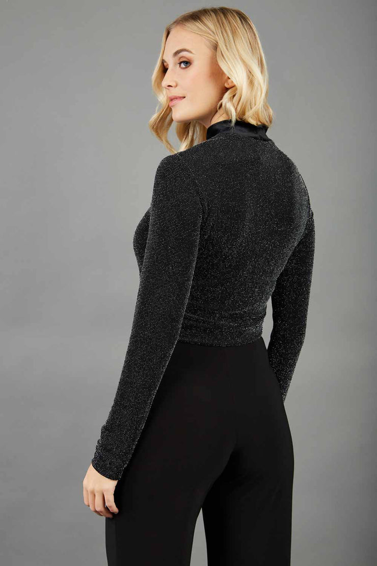 Blonde hair model is wearing a jersey sparkle velvet turtleneck blouse top  front image