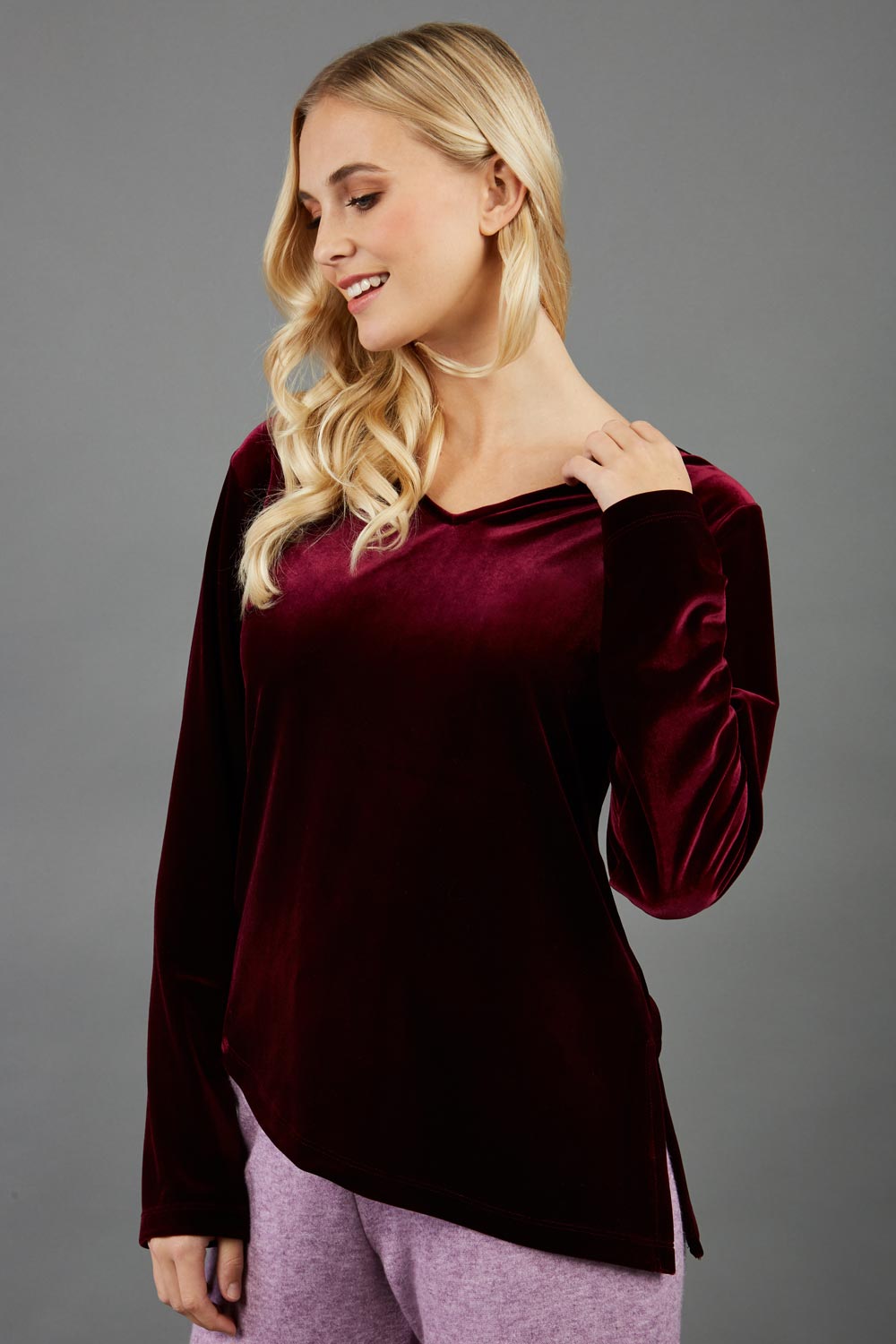 blonde model wearing diva catwalk dahlia asymmetric velvet top with sleeves in red front