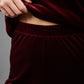 model wearing diva catwalk pelham stretch velvet straight leg trousers in velvet with ribbon in burgundy colour front
