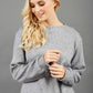 blonde model wearing diva catwalk muscari asymmetric sleeved top with rounded neck in flint grey front
