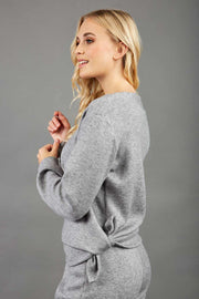 blonde model wearing diva catwalk muscari asymmetric sleeved top with rounded neck in flint grey front