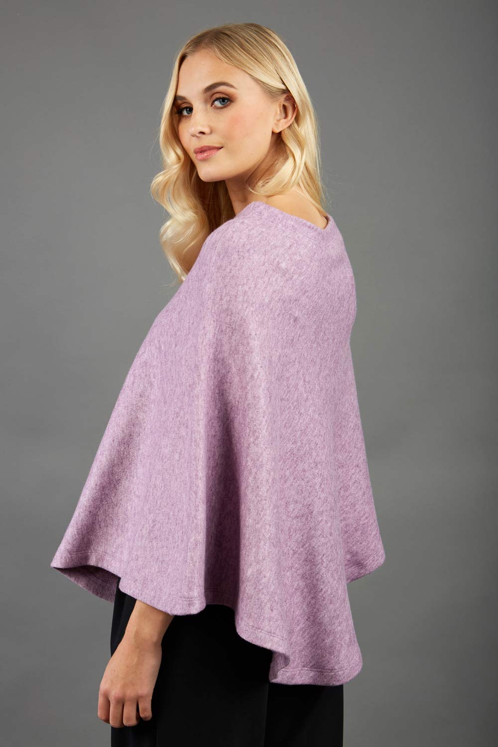 blonde model wearing diva catwalk rosalia poncho made in very cosy soft cashmere fabric in pink side