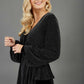 Blonde hair model is wearing a jersey sparkle v neck wrap blouse with bishop sleeve detail and bow on a side side image
