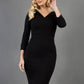 blonde model wearing damsel little black pencil dress with long sleeves and v neckline front