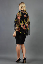 blonde model is wearing diva catwalk valparaiso black floral cape paired with diva sleeveless pencil black dress back