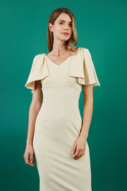 brunette model is wearing diva catwalk hermione pencil dress with tie shoulder details and empire waistline in beige front