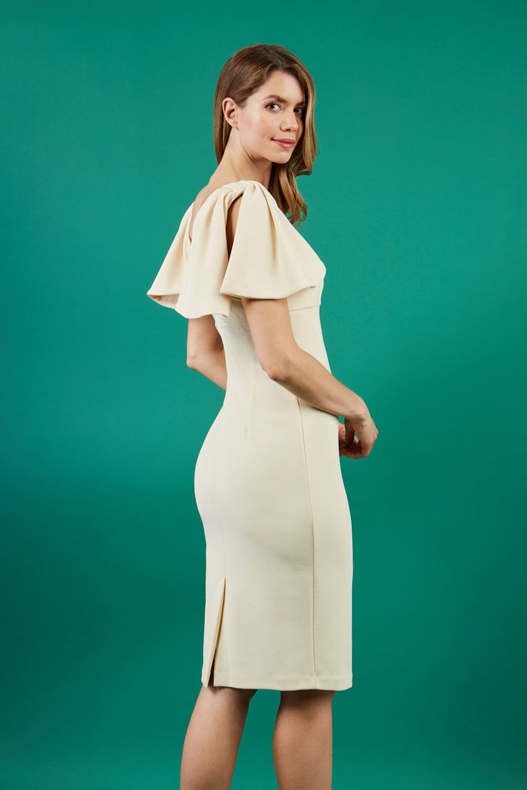 brunette model is wearing diva catwalk hermione pencil dress with tie shoulder details and empire waistline in beige side
