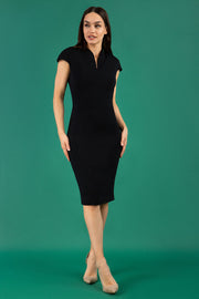 A brunetter model is wearing a pencil cap sleeve dress with the zip neckline detail in black