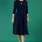 Brunette model is wearing diva catwalk casares swing dress with a keyhole neckline three quarter sleeve dress with pocket detail in navy blue front