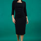 model is wearing diva catwalk plaza sheath dress with high neck Trapezium neckline cutout and three quarter sleeve pretty dress in black front