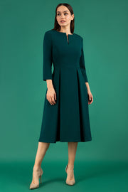 A brunette model is wearing a split neckline sleeved swing Aline dress from Diva Catwalk front image in forest green