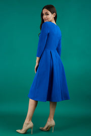 Model is wearing a split neckline sleeved blue swing Aline dress from Diva Catwalk back image