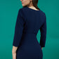 model is wearing diva catwalk chandos sheath dress with three quarter sleeve and slit in the middle of the neckline in navy blue back