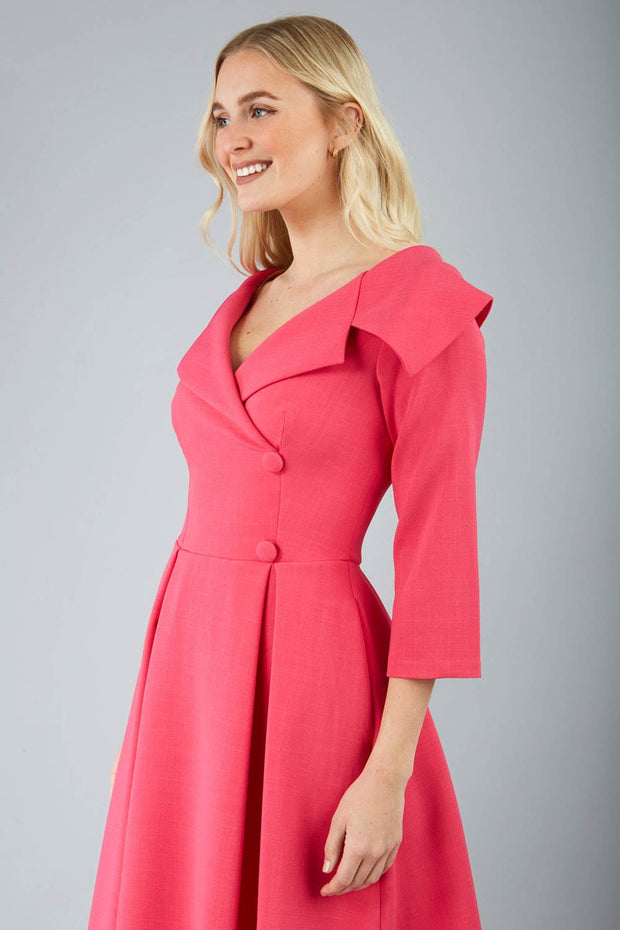 model is wearing diva catwalk gatsby swing dress with pocket detail and wide v-neck collar and buttons down the front panel in pink side close up