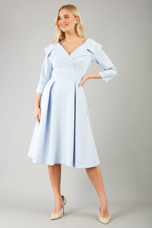 model is wearing diva catwalk gatsby swing dress with pocket detail and wide v-neck collar and buttons down the front panel in celestial blue front