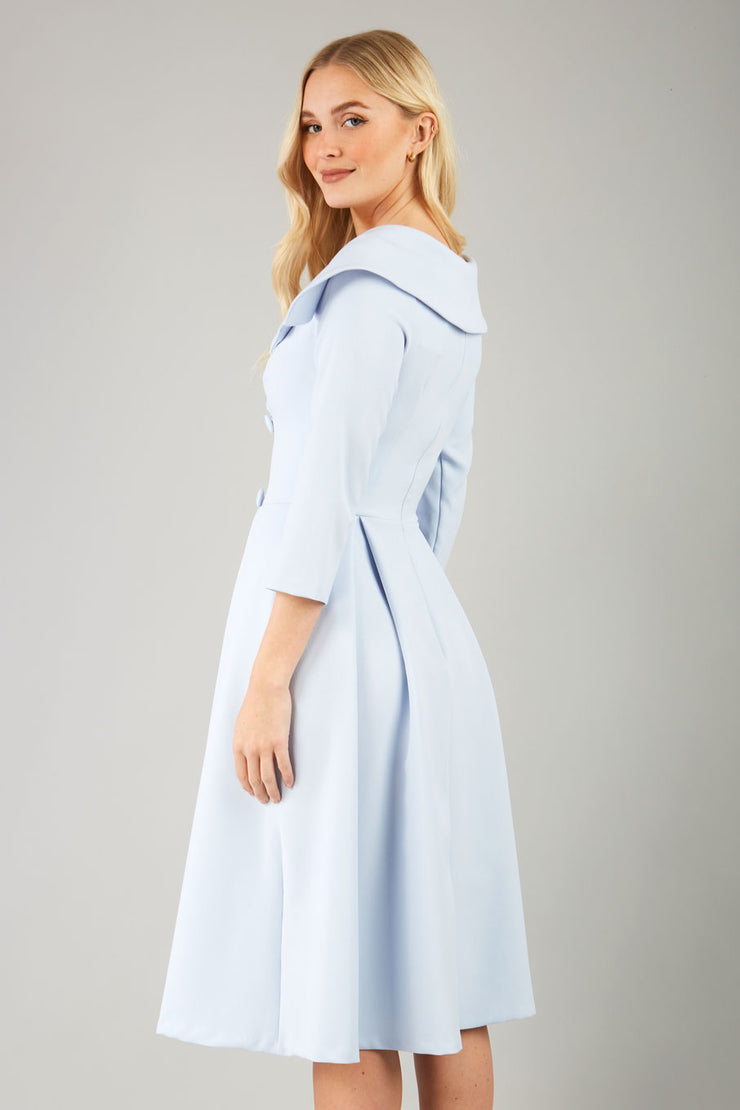 model is wearing diva catwalk gatsby swing dress with pocket detail and wide v-neck collar and buttons down the front panel in celestial blue side front