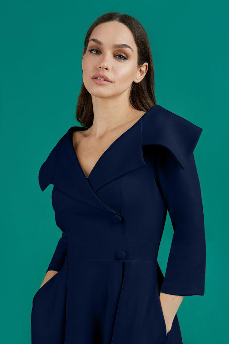 model is wearing diva catwalk gatsby swing dress with pocket detail and wide v-neck collar and buttons down the front panel in navy blue front